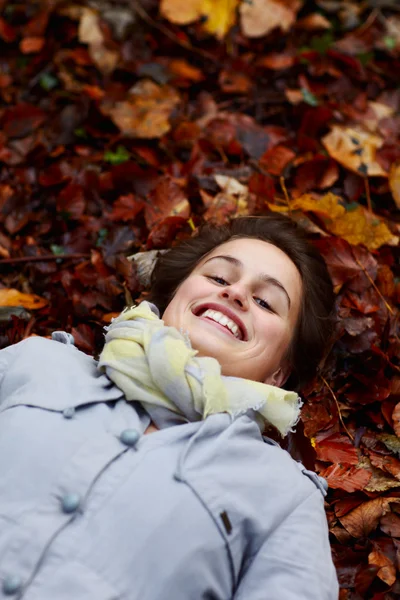 Dospívající dívka leží v podzimní listí — Stock fotografie