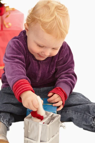 Baby spielt mit Weihnachtsgeschenken — Stockfoto