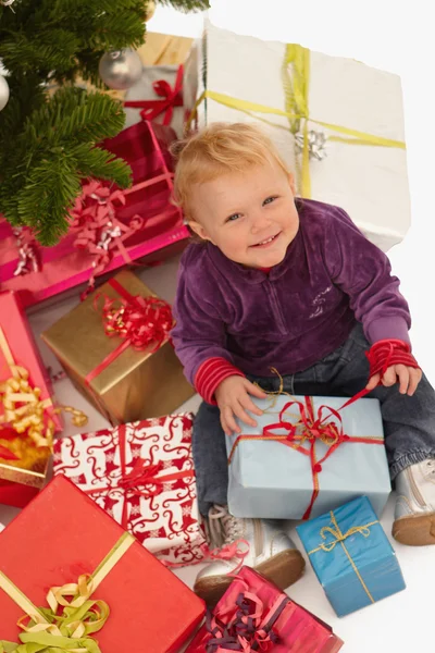 Baby looking up with christmas gifts — Stock Photo, Image