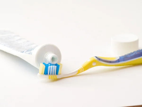 Zahnbusch und Zahnpasta auf weiß — Stockfoto