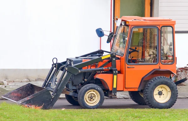 Turuncu traktör Kepçe kepçe ile — Stok fotoğraf