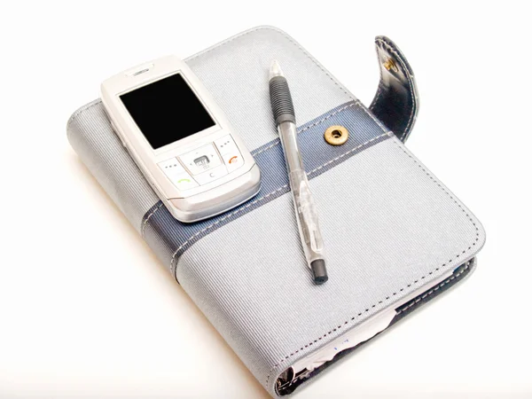 Diário da caneta e um telefone celular — Fotografia de Stock