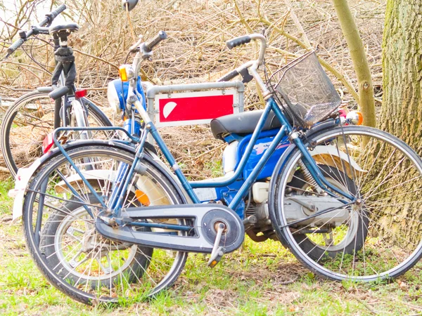 Oude ouderwetse fietsen rusten op een teken — Stockfoto