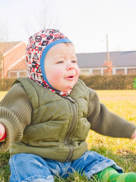 Dışarıda çimenlerin üzerinde oturan erkek bebek — Stok fotoğraf
