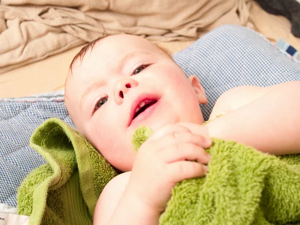 Söt baby pojke ligger insvept i en handduk — Stockfoto