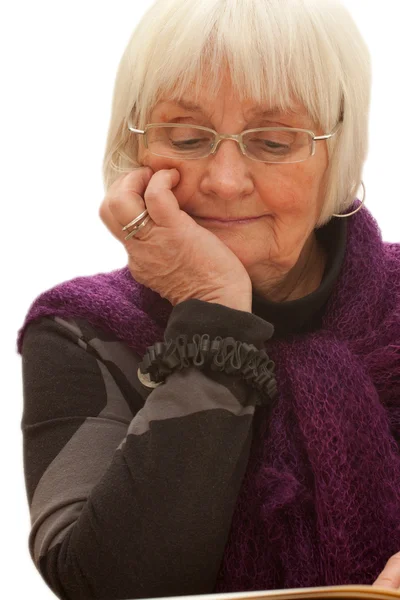 Thoughtful older woman reading a book — Stock Photo, Image
