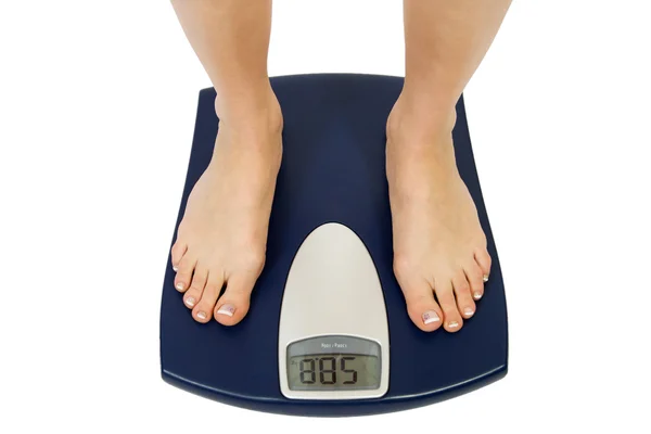 Female feet standing on a bathroom scale — Stock Photo, Image