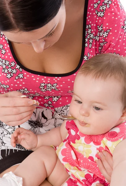 Jovem mulher alimentando sua filha bebê — Fotografia de Stock