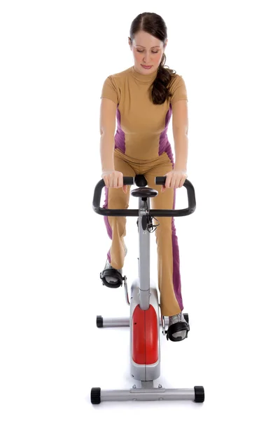 Donna che fa fitness su una bici stazionaria — Foto Stock