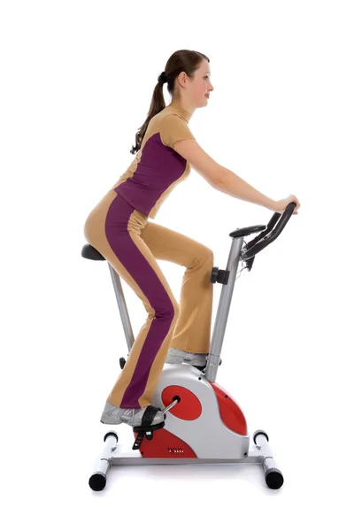 Kobieta robi fitness na rowerze stacjonarnym — Zdjęcie stockowe