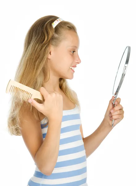 Teen girl look in to mirror and combing — Stock Photo, Image