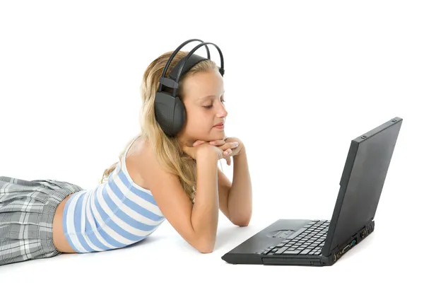 Ragazza adolescente sul computer portatile con auricolari — Foto Stock