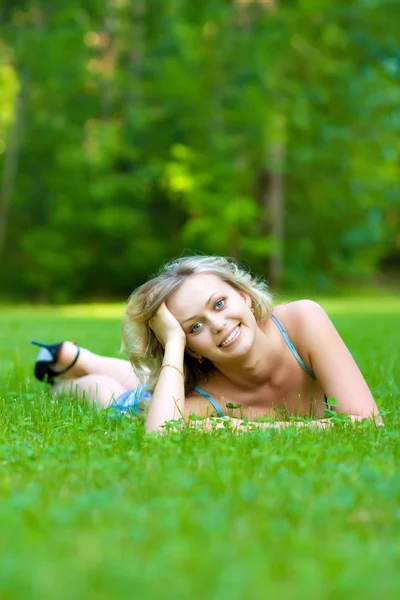 Νεαρή γυναίκα που βρίσκεται σε ένα πράσινο γρασίδι — Φωτογραφία Αρχείου