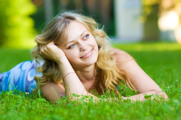 Jeune femme couchée sur une herbe verte — Photo