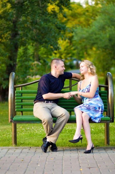 Couple in love sitting at a bench — Stock Photo, Image