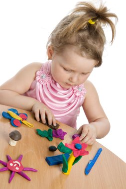 Girl playing with color play plasticine clipart