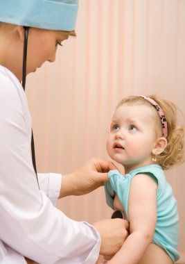 Doctor examines baby using stethosc clipart