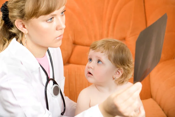 Доктор відвідує дитину і дивиться на рентгенівський знімок — стокове фото