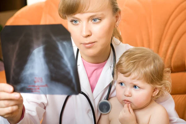 Doutor visita bebê e olhando para um raio-x — Fotografia de Stock