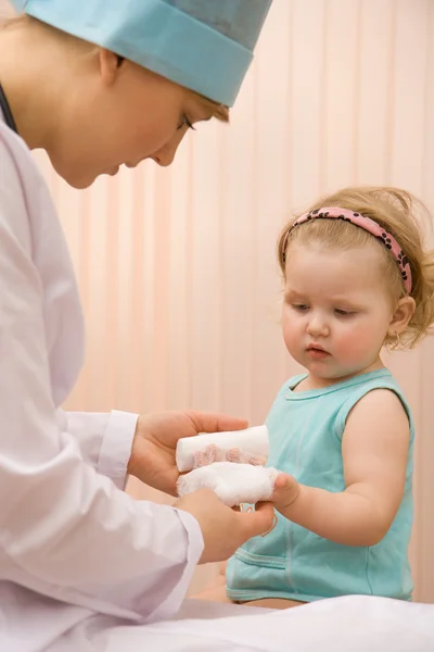 Лікар кладе пов'язку на руку дитини — стокове фото