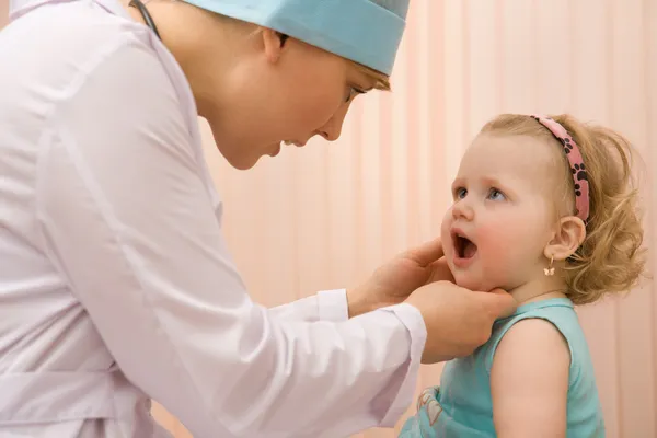 Médico pediatra examen bebé boca Imágenes de stock libres de derechos