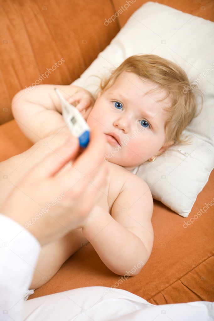 Doctor with baby and reading thermometer
