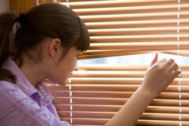 Teenager girl looks out of the window clipart