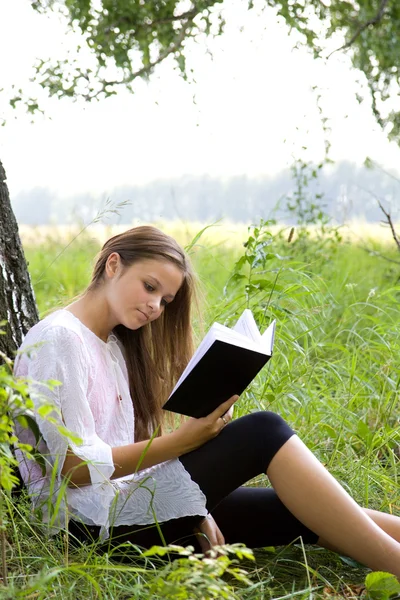 Ung flicka läsa bok i parken — Stockfoto