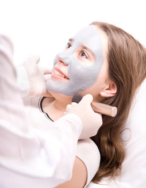 stock image Beautician applying a clay face mask