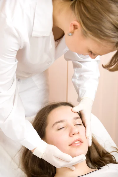 Beautician explored face of young women — Stock Photo, Image