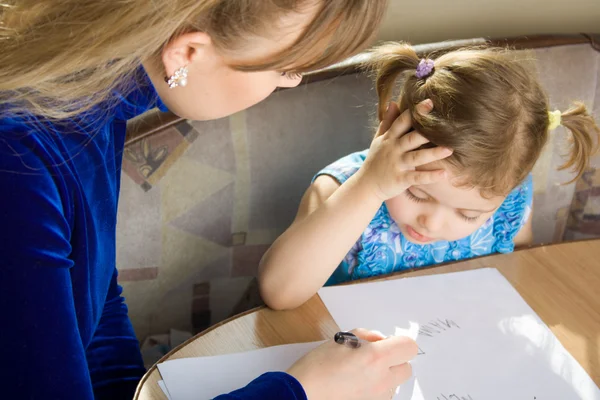 Маленькая девочка учится писать — стоковое фото