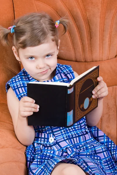 Menina leitura livro e sorrisinho — Fotografia de Stock