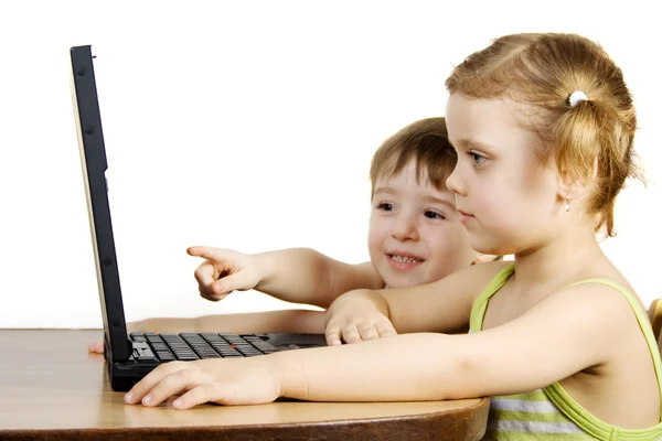 Irmã e irmão trabalhando com um laptop — Fotografia de Stock