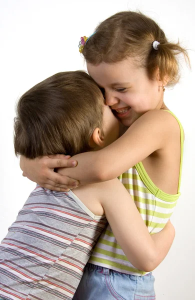 Usmívající se dívka objímá malého chlapce — Stock fotografie