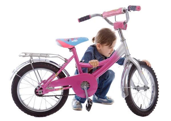 Молодая девушка чинит велосипед — стоковое фото