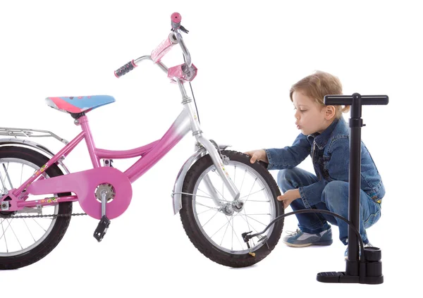 Jong meisje opblazen haar fiets wiel — Stockfoto