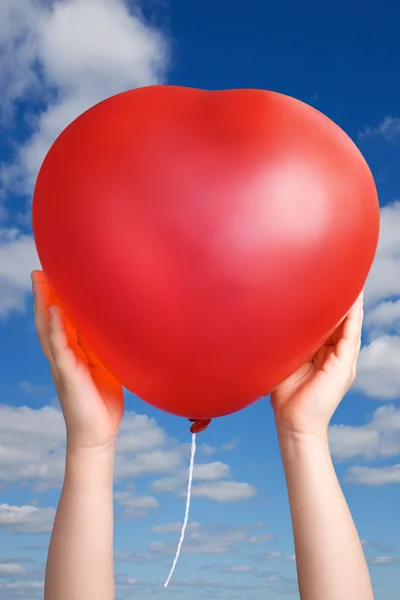 Red balloon in child hands — Φωτογραφία Αρχείου