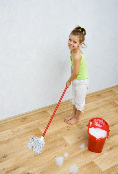 Klein meisje reiniging van de vloer — Stockfoto