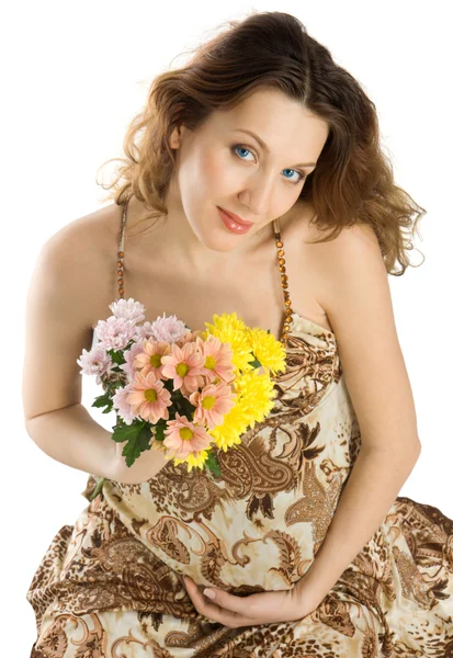 Улыбающаяся беременная брюнетка с цветами — стоковое фото