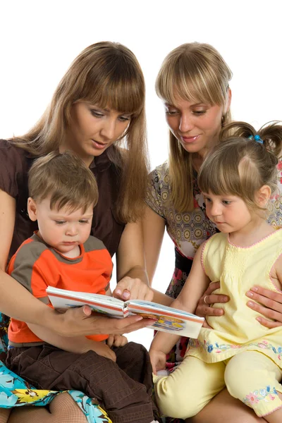Twee moeders lezen boeken aan hun kinderen — Stockfoto