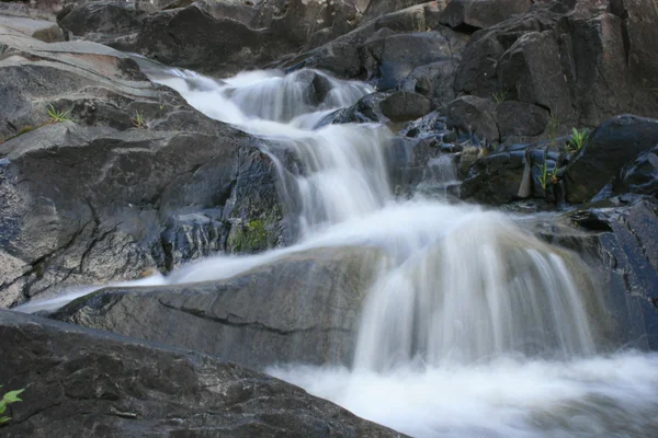 Вода, текущая над камнями — стоковое фото