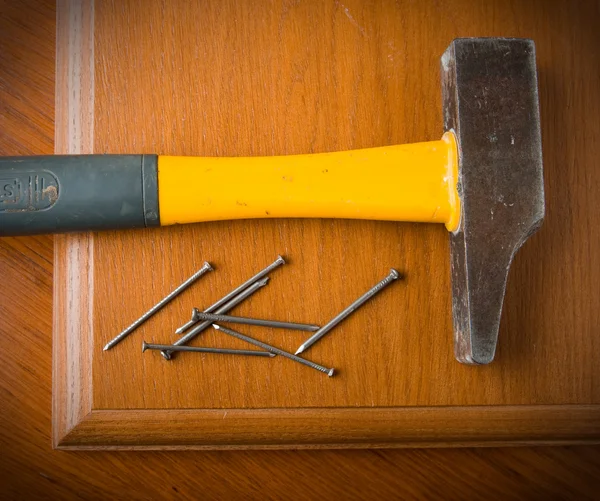 De hamer, spijkers liggen op een houten tafel. — Stockfoto