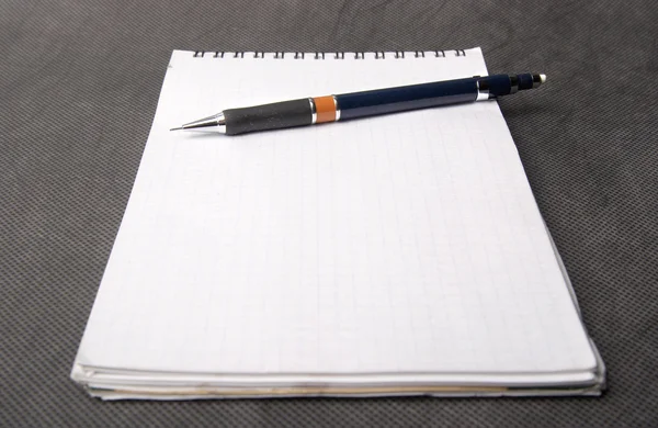 Lápis deitado em um caderno — Fotografia de Stock