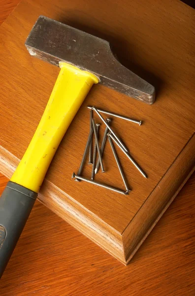 Der Hammer, Nägel liegen auf einem Holztisch — Stockfoto