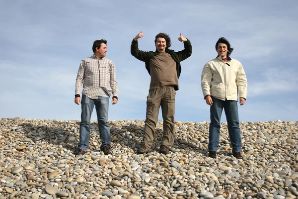 Три случайных молодых человека на пляже — стоковое фото