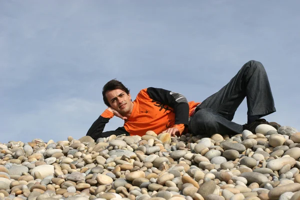 Człowiek, opierając się na jednej ręce na plaży — Zdjęcie stockowe
