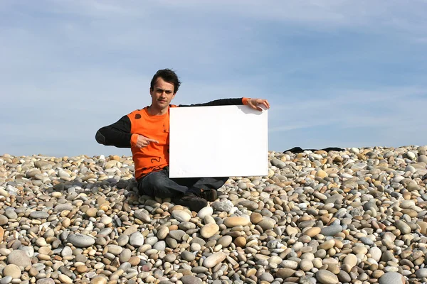 Man Holding White Card at the beach — Stock Photo, Image