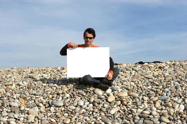 Man med vitt kort på stranden — Stockfoto