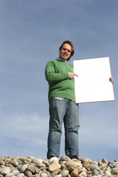 Muž, který držel bílou kartu na pláži — Stock fotografie
