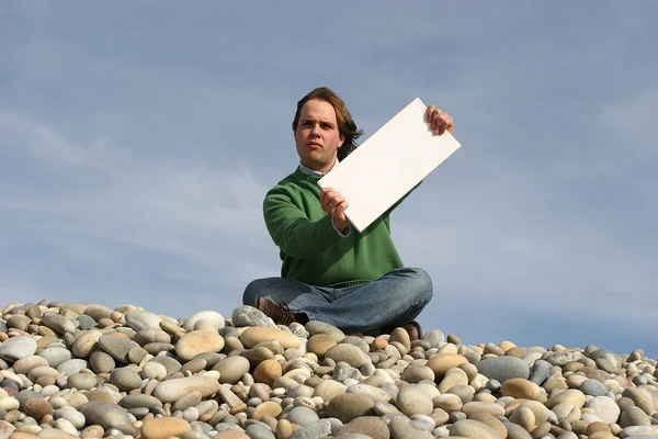 Muž, který držel bílou kartu na pláži — Stock fotografie